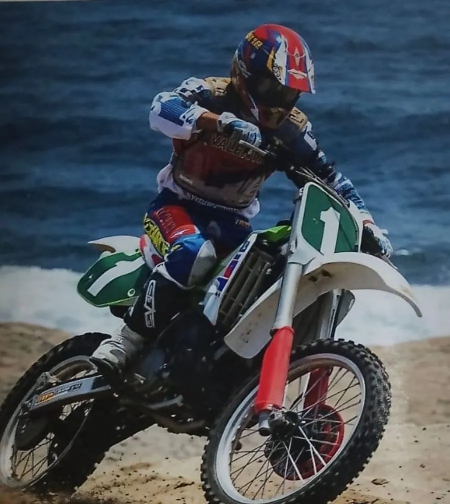 Oreste Valenti in moto sulla sabbia in riva al mare, con il numero 1